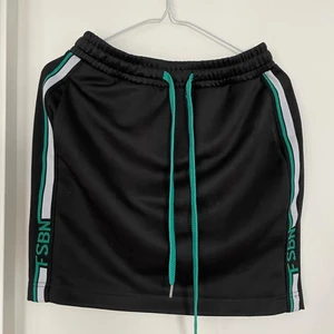 New Yorker Svart kjol XS - Använd två gånger. Har fickor. Justerbar midja. Gröna och vita detaljer. Köparen står för frakt.