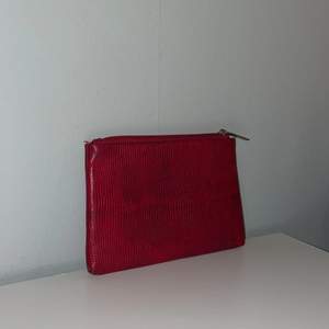 En liten röd väska. Perfekt att ha i väskan med ex  tamponger, bindor eller läppglans.                                    Köparen betalar för frakten.