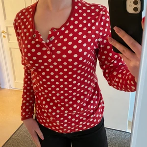 Långärmad röd, vit prickig tröja - Långärmad tröja som sitter fint med tre knappar.