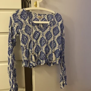 Blus - En sååå fin blus från hollister. Den har vida ärmar med en slits. Tofsar som hänger ner från urringningen och så är den i ett jätte svalt material som gör den perfekt på sommaren! Endast använd ett fåtal gånger!