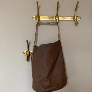 Handväska  - Brun väska med guldiga detaljer från dondonna. ca 30x40 cm så datorn får plats👍 