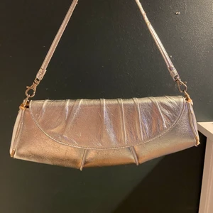 Silvrig väska  - En väska jag köpt second hand som typ aldrig använder längre. Den är lite skadad på sidan och bandet 