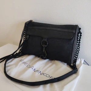 Mini M.A.C. Crossbody från Rebecca Minkoff - Säljer en Mini M.A.C. Crossbody bag i svart mocka från Rebecca Minkoff. Nypris 1858 kr. Väskan är i mycket fint skick. Det finns lite slitage på metalldetaljerna (se bild) men det är omärkbart när man använder den. Axelbandet är justerbart och väskan kan bäras både över axeln och som crossbody. Dustbag följer med!  Köparen kan välja att lägga till spårbar/rekommenderad frakt, då till extra kostnad. 