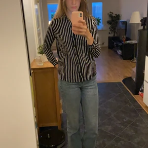 Svart vit randig skjorta - Svart och vit randig skjorta i stl 36 säljes. Den är använd ett fåtal gången men är i princip i nyskick. Skjortan är rekativt pösig men kan stylas på olika sätt som på bilden till exempel. Passar till vardagligt bruk men även till finare tillfällen.