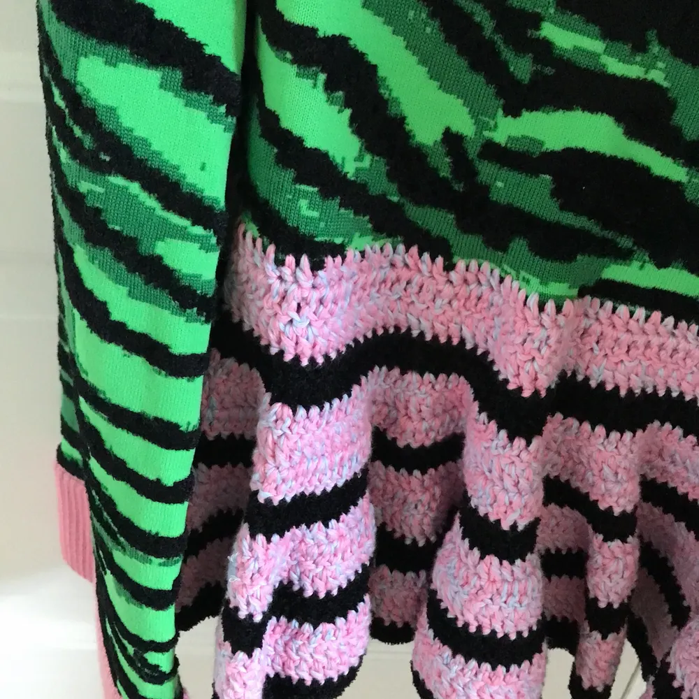 Denna är helt oanvänd. Den har ett litet litet hål på framsidan (se bild 2). Oversized fit. Med zebra mönster i svart och grönt och rosa och svart stickad nertill.. Tröjor & Koftor.