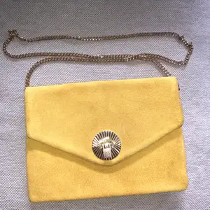 Jättefin kuvertväska i gult med gullig kedja och spänne. Endast använd 1 gång så den är i princip i nyskick! 