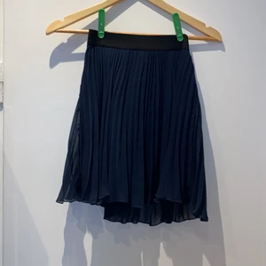 Volangkjol från Abercrombie & Fitch  - Mörkblå volangkjol från Abercrombie & Fitch i storlek XS. Kjolen har ett undertyg och sedan volangtyg utanpå och resår i midjan. Kjolen är ca 43cm lång. Färgen överensstämmer med första bilden där kjolen hänger från en galge. Säljer även en i rött.