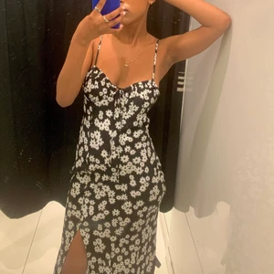 Klänning - En blommig klänning, lång med slit på framsidan. Jätte fint och sitter jätte bra på kroppen. Använt två gånger under sommaren.