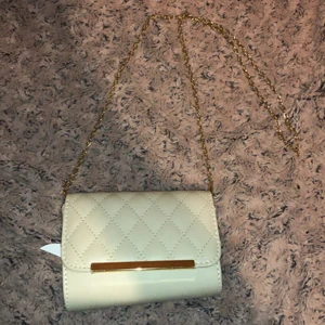 Väska  - En superfin ljus beige väska med guld detaljer, finns en liten ficka som man kan stänga inne. Man kan ta bort kedjan så att det blir till en hand väska.✨🥰            (Aldrig använd) 