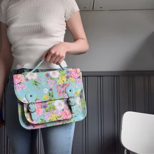 Färgglad väska - Färgglad väska med blommor i superfina pastellfärger från Claire's🌸Fint skick! Ingår längre axelrem för att bära crossbody om man vill(kommer med i väskan-bild3). Frakt 66:- spårbart💌