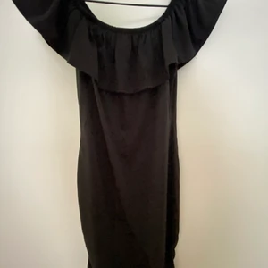 Svart klänning  - Svart tight klänning med volanger, oanvänd 