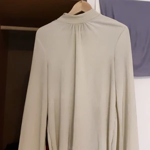 Fin veckad satin tröja med utsvängda armar  - Produkten är köpt från Nakd. Storleken är 36/S och materialet är i fin satin som är veckad! Fin att använda till fest eller utekvällar