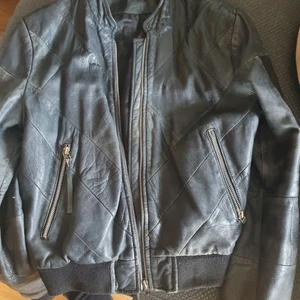 Läderjacka begagnad!  - Äkta skinnjacka som bär 12 år på nacken. Helt oanvänd på 6 år eftersom att jag är vegan. Den är sliten och har lite hål efter att ha haft pins i sig. Säljer den därför superbilligt! Du som gillar sliten stil och vill färga den själv och göra vad du vill med den passar denna för. Passar 32/34 och 36. Beroende på hur man vill att den ska sitta på kroppen! Frakt tillkommer :)  Vill gärna att den ska komma till nytta utan att ett djur ska ha behövt sätta livet till i onödan. Hjälp mig bli av med den 🙌 Tack!