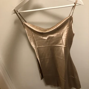 Fin siden klänning XS - Fin siden klänning från Shein storlek XS, endast provad! Orginal påse finns, säljer så den var för liten. Färgen är lite Champangefrägade med lite mörkare ton