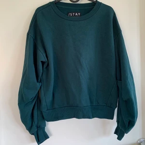 Grön croppad sweatshirt - En mörkgrön sweatshirt i croppad modell med detaljer på insida ärm för snyggt fall och passform. Använd men i fint skick! Storlek S