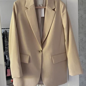 Beige Kavaj  - En fin oanvänd beige kavaj från H&M, i storlek XS 🤎 jag säljer den för att den inte använts av mig. Prislappen sitter kvar, och den har bara hängt i min garderob! Är ni intresserad av den, kan ni gärna kontakta mig! Köparen står för frakten, och köpt är köpt 🥰 