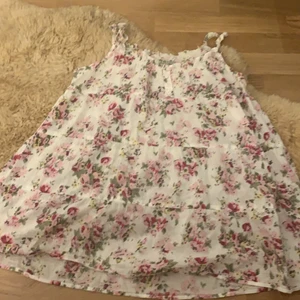 Ett linne med blommor på storlek 158/164 - Detta är ett linnne med blommor på haft det ungefär 5 gånger det är i storlek 158/164 men väldigt strätchit så kan någ passa s i väldigt fint skick 