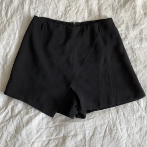 Svart Byxkjol  - Snyggaste festshortsen! Blir så snygga på och sitter inte tight på benen men snyggt på rumpan. Finns hållare att använda ett snyggt bälte i. I elegant material så är av bra kvalitet och ser inte billigt ut. Säljer pga för små :( står storlek M men de är köpta i Singapore och är närmare en svensk XS/S