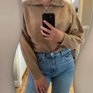 Stickad tröja storlek XS - Stickad tröja med dragkedja. Tröjan är i storlek XS men jag skulle säga att den även passar storlek S och M. Man kan vika ner den som på bilden, eller dra upp dragkedjan hela vägen upp som en polotröja. Skickas såklart tvättad.