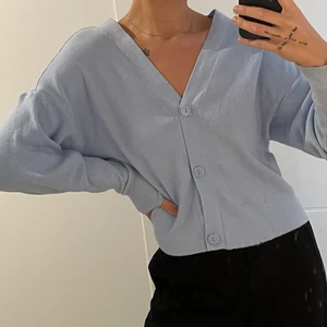 Baby blå Cardigan  - Säljer denna super söta babyblåa cardigan från NA-KD. Använd kanske 2 gånger. Storlek S. Super söt verkligen🦋🦋 Fraktkostnad tillkommer!