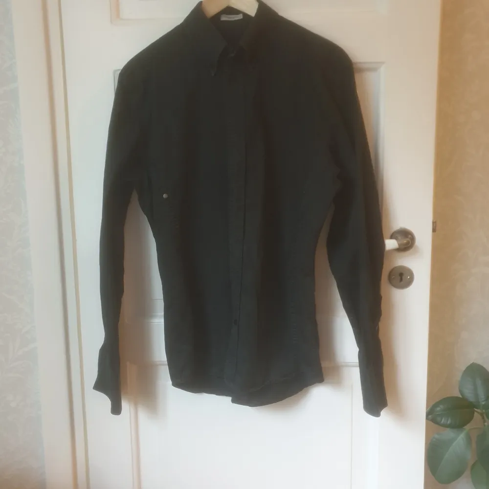 svart skjorta Storlek: S. 100% bomull detaljer: små knappar på fram och baksidan. Skjortor.