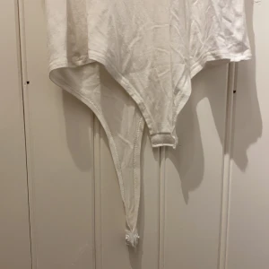 Vit body - Vit stringbody från Nelly. Använts ett fåtal gånger. Vill sälja då jag inte är så förtjust i body’s! 