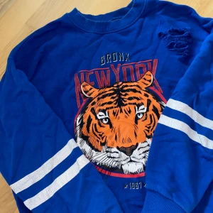 Gina Tricot Tröja  - En blå tröja från Gina Tricot! En väldigt fin färg. Hålen i tröjan är orginal, så det är ingenting som jag själv har gjort. I fint skick✨ storlek XS men passar även S! 