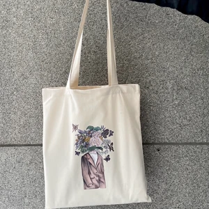 Tygkasse - Naturvit tygkasse med handmålat motiv, superfin! Den är i nyskick, helt oanvänd. Kvaliteten är god och den är gjord av återbunnet bomull, från mitt UF-företag! Kan posta eller mötas upp i Göteborg💜 Det finns flera på lager🎉