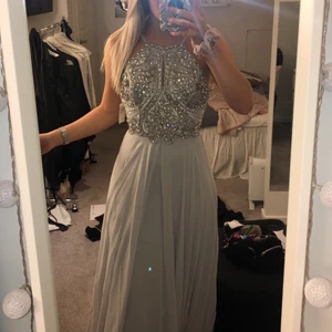 Balklänning Strl xs - Säljer min fina balklänning som aldrig kom till användning tyvärr. Den är från Dressroom Linné och är i storlek 2 vilket motsvarar xs, den är sann i storleken. Den är inte uppsydd och passar på folk upp till 175cm eventuellt 180. Nypris är 5500kr. Säljs för 3000kr. Färg: ljusgrå/silver 