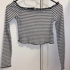 Croppad långärmad tröja! - En randig snygg topp. Köptes på Hm för ganska längesedan. Sitter fint och tajt på. Den är croppad så magen syns. Man kan välja att ha den så att axeln syns om man vill det. Har använt denna några gånger innan. Men annars har den bara legat i garderoben. Är i nyskick! Är i storlek Xs. Obs! Vill du ha fler bilder på hur den ser ut på så är det bara att meddela! ❤️