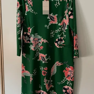 Elegant klänning  - Oanvänd, då det inte funnits tillfälle att bära den. Nypris 800 kr. Säljes för 600 kr. Porto tillkommer på 92 kr. Tjockt stretchtyg. Storlek L. Liten i storleken. 