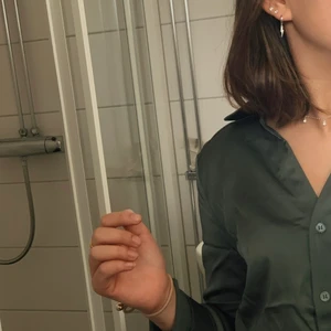 Skjorta i satin - Grön skjorta i satin eller liknande material, köpt från HM förra julen, kommer inte till användning så bra skick! Jag står för frakten, hör av dig för fler frågor❣️