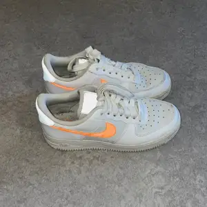 Vita Nike Air Force 1 med orange swoosh/söm och några ljusgråa partier, reflex på plösen och hälen, i storlek 36.5. Använda några gånger bara, knappt ingångna. Köpta från Footish för några år sedan men kan inte hitta dom där längre. Säljer för 350kr. Finns att hämta i Eskilstuna. Finns på flera sidor.