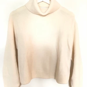 Vit stickad tröja från other stories - Vit stickad tröja med cut-out i ryggen. Storlek XS. Tröjan är i mycket fint skick, endast använd ett fåtal gånger. Den kan dock uppfattas smutsig eftersom ljuset är väldigt dåligt. Nypris 690kr.