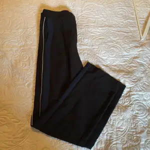 Svarta byxor från Monki med blå och vita ränder vid sidan! Köpta secondhand☺️ Säljes eftersom dom är för korta för mig!