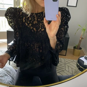 Svart spetsblus från Zara - Svart blus i spets från Zara. Croppad modell med puffiga axlar. Storlek XL. Aldrig använd.