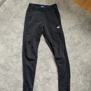 Mjukisbyxor från adidas - Svarta mjukisbyxor från adidas. Använd ett fåtal gånger. Byxorna har svarta streck på sidorna. Stolek XS