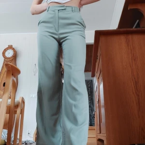Ljusgröna kostymbyxor  - Ett par ljusgröna kostymbyxor. Väldigt fin färg och bra + mjukt material. Sitter tyvärr lite tight på mig, storlek 34 på brallorna