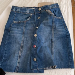 Kjol med knappar  - Från Gina 