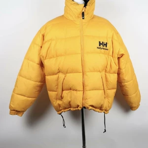 Fet Retro Vintage Helly Hansen Dunjacka oversize puffer i toppklass - Storleksmärkt Herr, Large. Stor och puffig, otroligt snyggt skick. Mått från nacksöm till ryggslutet är cirka 71-72 cm (Krage är inte inräknad). Har även fett tryck av Helly Hansen loggan på insidan av fodret men kunde inte lägga till fler bilder så mejla gärna om ni vill se. Härlig industri-gul nyans på jackan. Det är snart vår men den här blir leka het nästa vinter och vintern efter det <3  Fyndat från Myrorna i Göteborg stad.  Säljs enbart då den blev "för oversize" på mig som är korta 157 cm (slutar under rumpen på mig). Så gillar men de "yeezy" fit och är kort som mig blir denna jacka perfekt. Ligger dock även ute på Tradera så läggs ett bud där försvinner jackan härifrån så skynda fynda! Priset är diskuterbart vid snabb affär.