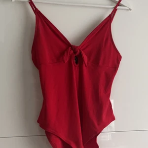 Jättesöt bodysuit med knytning - Jättesöt bodysuit med knytning där fram får bysten att se jättefin ut!! Skulle säga att den passar XS-L pga stretchen 