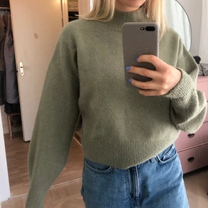 Stickad tröja med hög krage - Grön stickad tröja med hög krage från &otherstories. Något kort i modellen! Mycket fint skick.