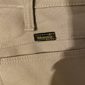 Wrangler byxor beiga kostymbyxor slacks - Jättefina och sköna wrangler byxor, de är vidare där nere. Är tyvärr för små och för korta för mig då jag är lång (179) och slutar över foten, så någon som är<165 eller vill ha croppat fit skulle nog gilla dessa. Jättefint skick, knappt använda
