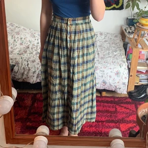 Lantlig långkjol - En långkjol i ett lantligt mönster. Gröna nyanser med bruna träknappar hela vägen ner. Insydd från en 42/44 till att passa mig som har 36. Finns hylsor för skärp!