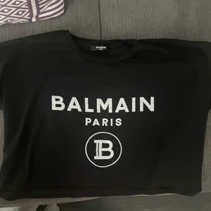 Balmain T-shirt  - En svart T-shirt från Balmain, köpt på Mytheresa kvitto ser ni på andra sliden. Använd fåtal gånger, skulle säga att den är i nyskick. Den är i storlek S men passar lika bra för personer med storlek XS & M.