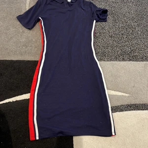 Tight klänning stl 38 - Tight klänning från H.M stl 38. Mörkblå klänning med blå och röda streck i kanten. 66kr frakt köparen står för frakten. Står ej för postens slarv! 