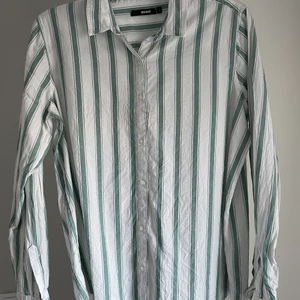 skjorta - oanvänd skjorta från Bikbok. randig med blå/gröna ränder. strl L. frakt tillkommer 