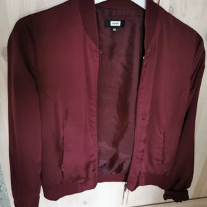 Vinröd tröja xs - Vinröd kofta/tröja i aningen glansigt material i storlek xs från bik bok. Använt skick. 