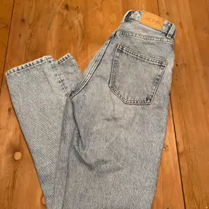 Ett par trendiga jeans från monki med hål på knäna och rosa text. Bra skick! 