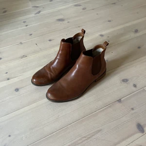 Skinnstövlar - Ett par bruna stövlar/Chelsea boots i fakeskinn. Så himla fina, är i gott skick, sitter snyggt och passar till typ allt, säljer pga lite för små för mig nu!! Det står storlek 42 men skulle säga att de passar 41 bättre!